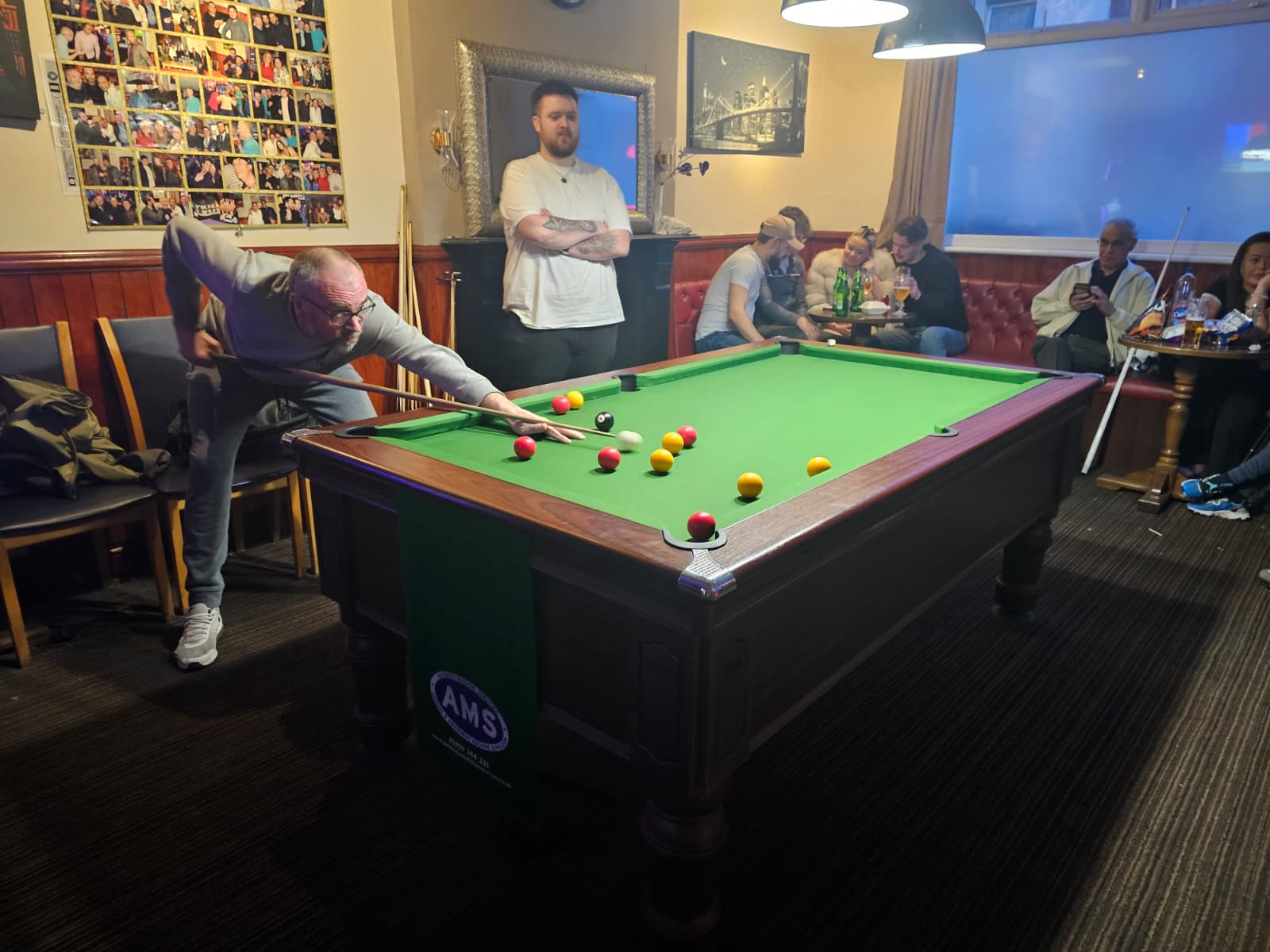 Pool tournament at The Weston Arms - player taking a shot while crowd watches